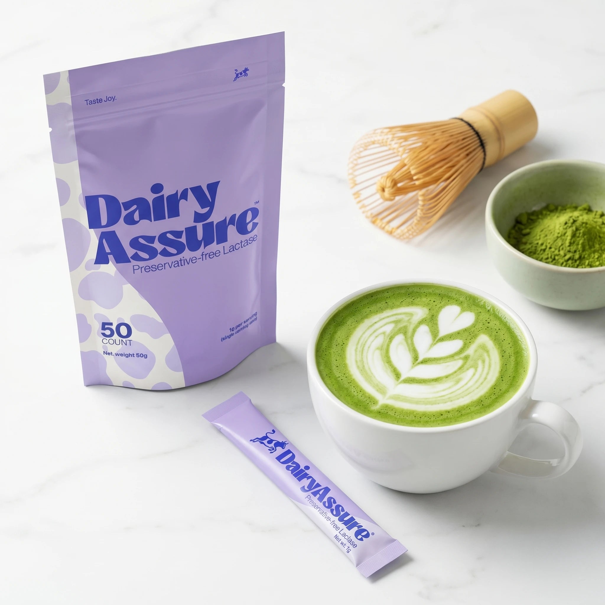 DairyAssure lactase sticks next to a matcha latte